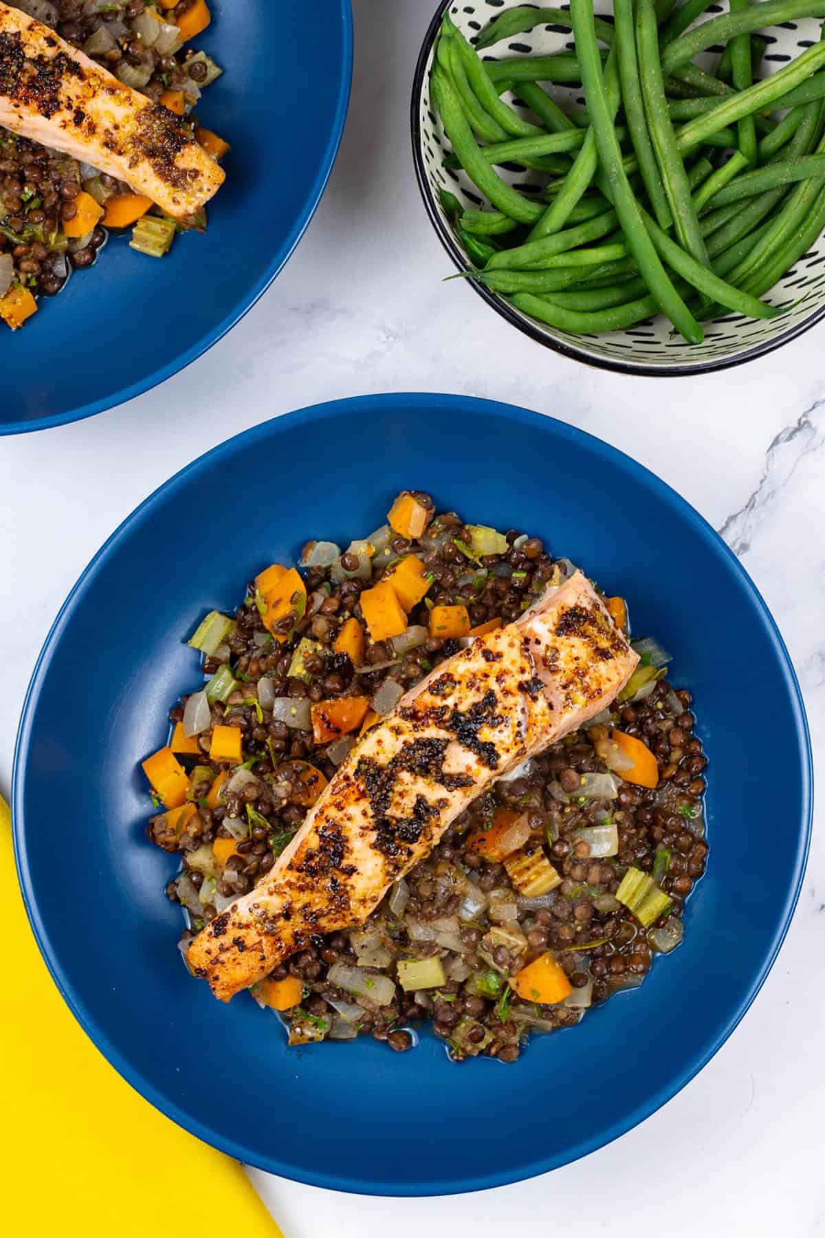 Two bowls of salmon with vegetable puy lentils, plus a dish of quick green beans on the side.