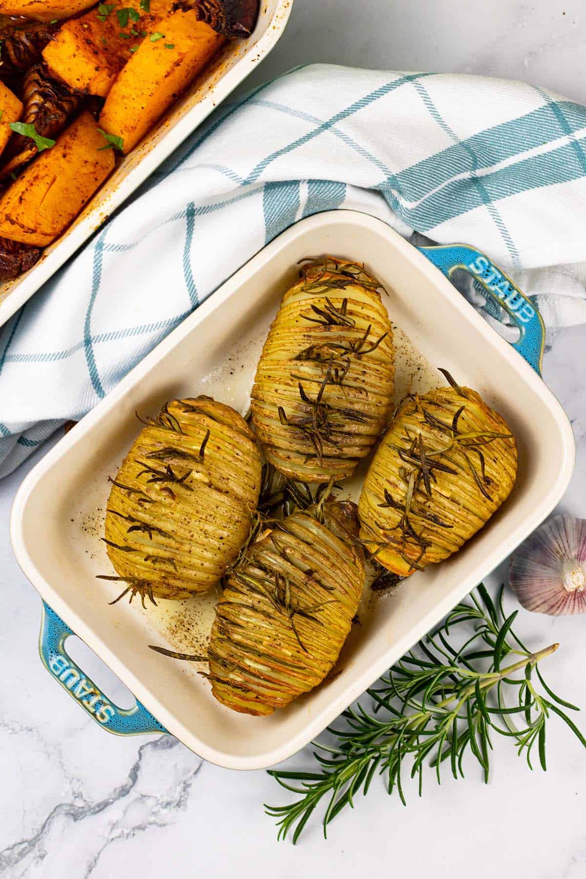 4 garlic and rosemary hasselback potatoes in a Staub ovenproof dish.