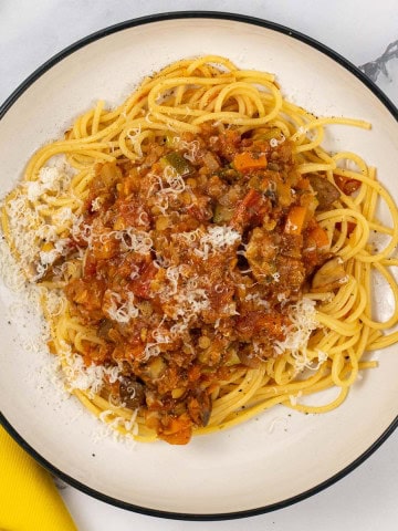 A bowl of lentil and vegetable bolognese with spaghetti.