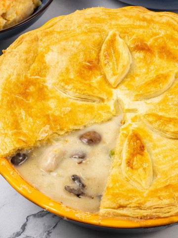 Creamy chicken and mushroom pie in a yellow pie dish.