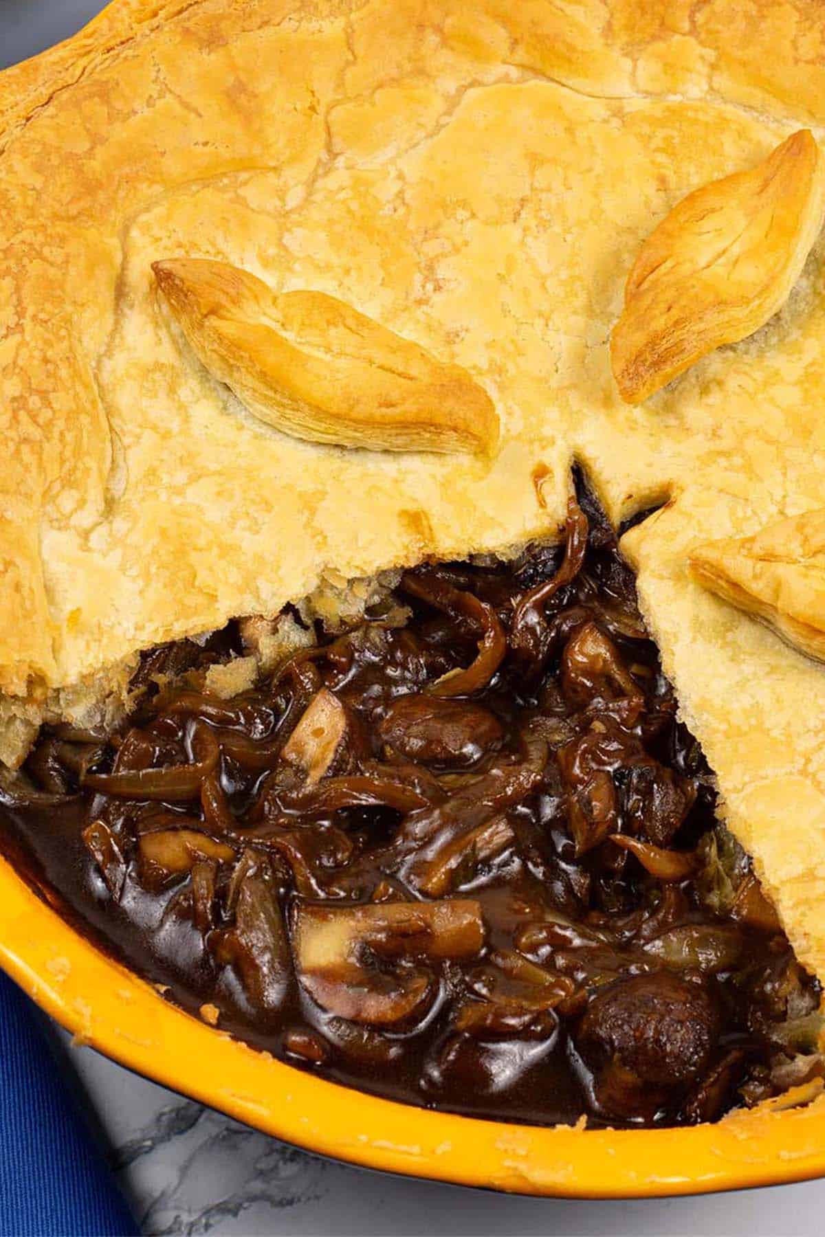 Mushroom and Guinness pie in a round yellow pie dish.