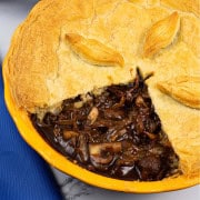 Mushroom and Guinness pie in a round yellow pie dish.