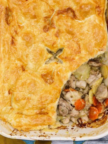 Easy chicken and vegetable pie in large rectangle oven dish with slice removed